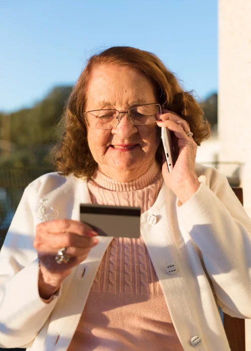 portrait-elderly-caucasian-woman-making-phone-call-holding-her-hand-credit-health-card